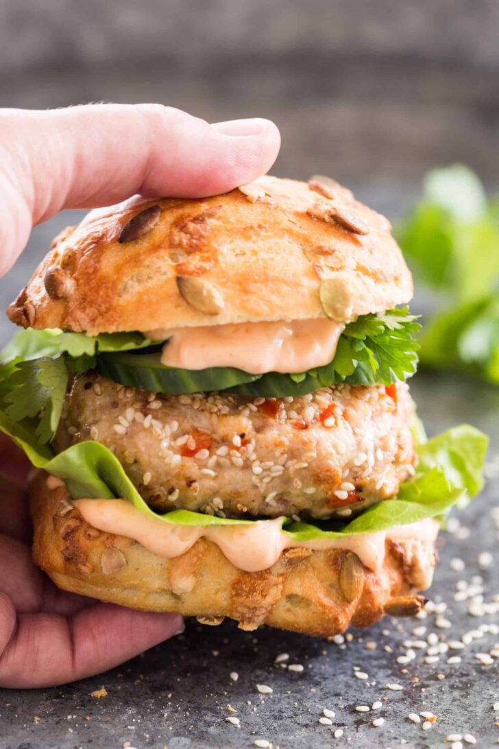 Asian chicken burger being taken by a hand